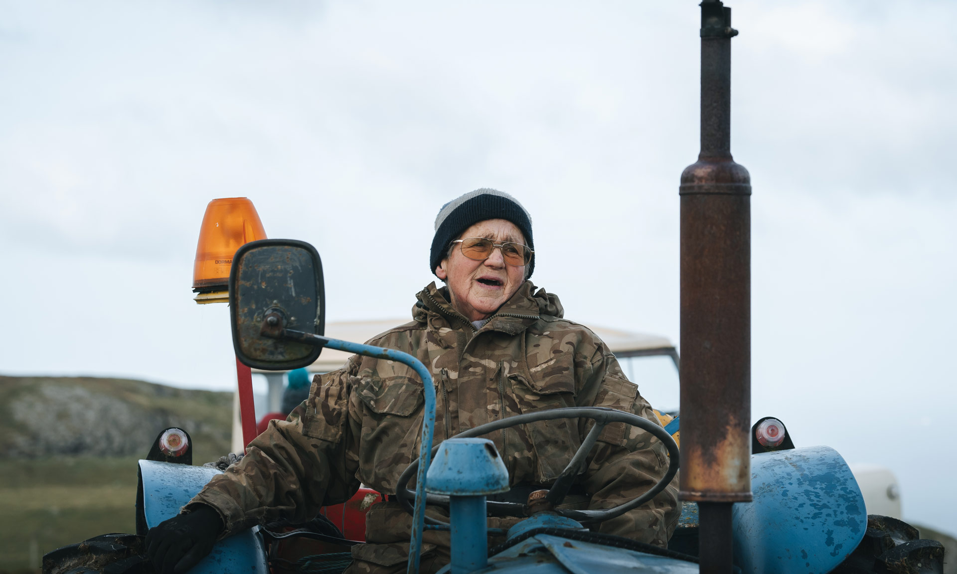 Farmer sits at her tractor