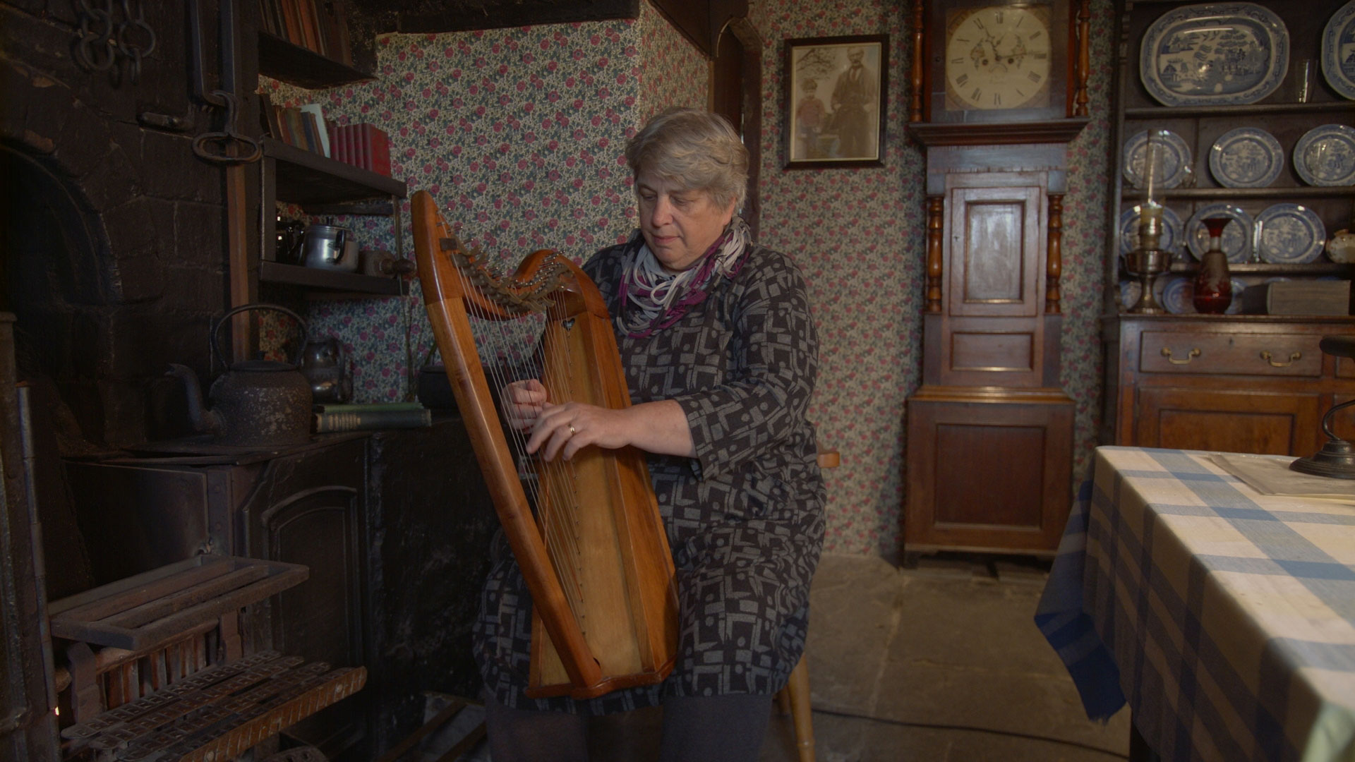 A still from a video of Mair Tomos Ifans reciting a story in front of the fire at Yr Ysgwrn.